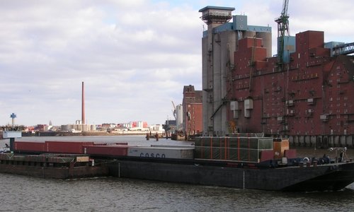 Binnenschiff HANNO mit Containern vor einem historischen Speichergebäude