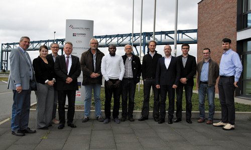 Gruppenfoto von zwölf Personen vor einem Schild von Brunsbüttel Ports