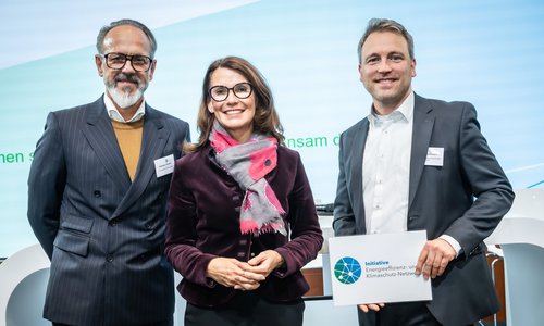 Drei Personen bei einer Preisverleihung mit Schild Energieeffizienz-Netzwerke