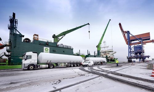 Tanklastzüge und Krananlagen am winterlichen Hafenkai bei einer LNG-Bunkerung