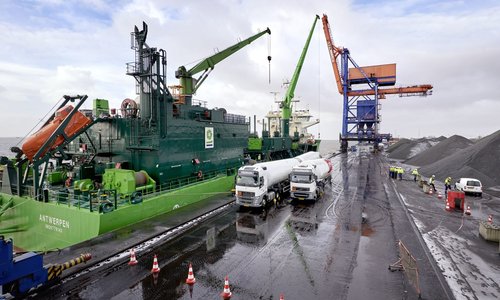 Schiff Antwerpen im Hafen, Kräne und Lkw mit Rotorblättern am Kai
