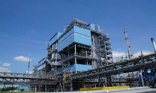 Blaue Industrieanlage mit Rohrleitungen unter blauem Himmel