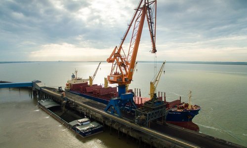 Luftaufnahme eines Hafenkrans beim Beladen des Schiffs BALTIC FOX