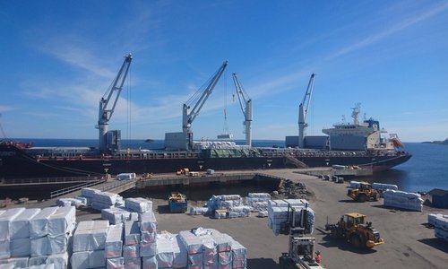 Frachtschiff am Kai in Schweden wird mit weißen Kranen beladen