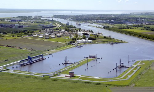 Luftaufnahme eines Hafenbeckens mit Tanklager an der Elbe