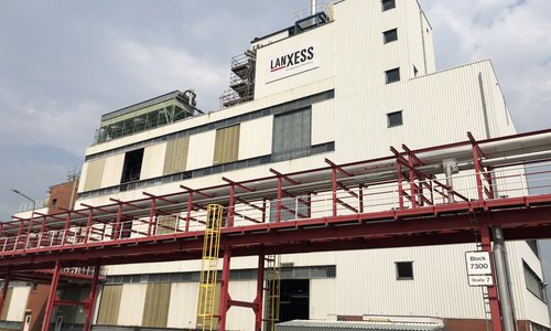 Werksgebäude von Lanxess mit Rohrbrücke und Schornstein