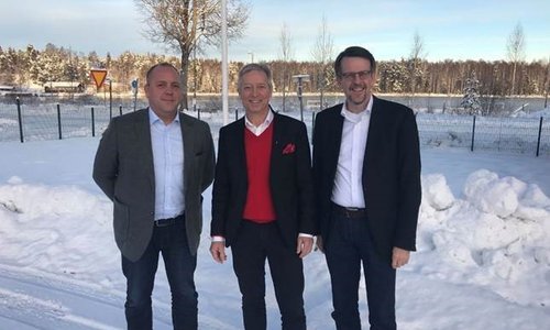 Drei Männer stehen im Winter vor einer verschneiten Landschaft